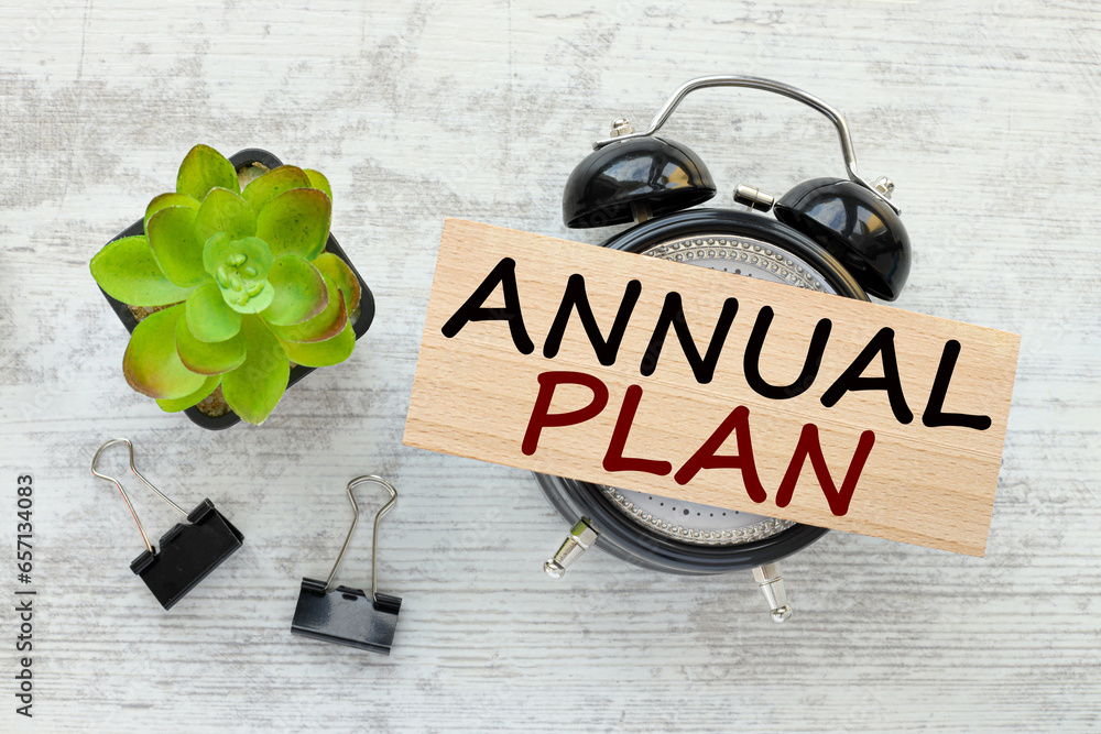 Poster annual plan. text on a wooden block on a table clock