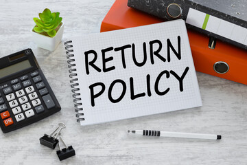 orange folder and calculator. Return Policy text quote on notepad, concept background