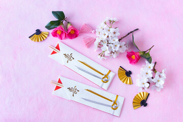 日本の正月　正月の祝箸と桜と椿と金色の扇（ピンクバック）