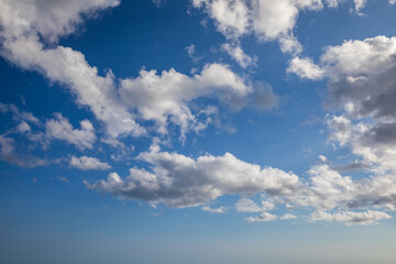 Sunny sky abstract background, beautiful cloudscape, on the heaven, view over white fluffy clouds, freedom concept. Aerial view of sky and white clouds. View from airplane.