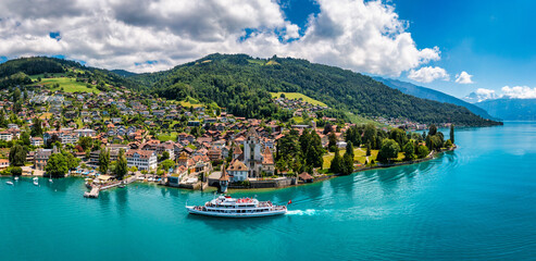 Oberhofen panoramic view at Lake Thunersee in swiss Alps, Switzerland. Town of Oberhofen on the...