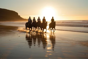 Fototapeten Silhouettes by the Sea: horse riding Group Enjoys afternoon on the Beach with Reflecting Sky and Water © idaline!