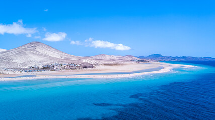 Drone shot of the beaches Playa de la Barca and Playa de Sotavento de Jandía with mountains and purple water on the island of Fuerteventura in Spain