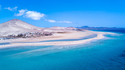 Drone shot of the beaches Playa de la Barca and Playa de Sotavento de Jandía with mountains and purple water on the island of Fuerteventura in Spain