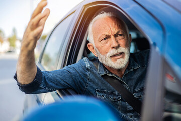 Angry senior man yelling out car window. Frustrated mature man driving a car and shouting at other driver. - obrazy, fototapety, plakaty