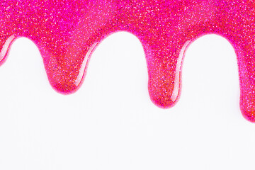 Pink glitter sparkle confetti background liquid drops of paint color flow down on white canvas. Dark pink glitter paint dripping on the white wall.