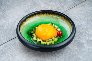Jelly dessert made from mango with kiwi, mint and cherry.