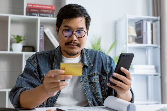 A man is using credit card to use financial payment or shopping online with mobile phone.