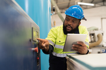 Factory male engineer worker working with digital table checking tank of air compressor in industry...