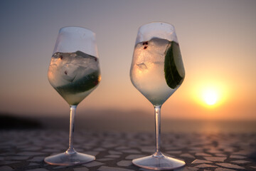 View of two delicious cocktails and an amazing sunset in the background in Ios Greece