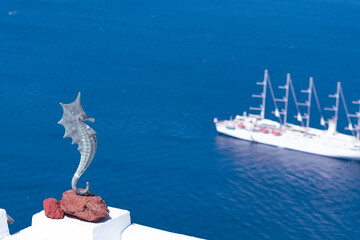 Decoration seahorse furniture in a Mediterranean Sea landscape with a cruise ship sailing in Santorini, Greece - obrazy, fototapety, plakaty