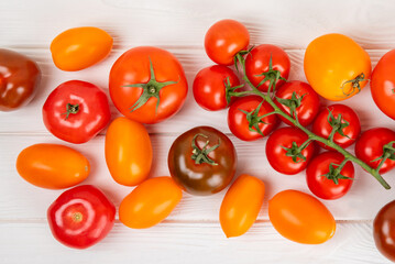 Tomatoes on marble texture background. Cherry tomatoes, yellow, pink, brown and black tomatoes in a bowl. Organic vegetables, harvesting.Vegan. Fresh ripe tomatoes. copy space.