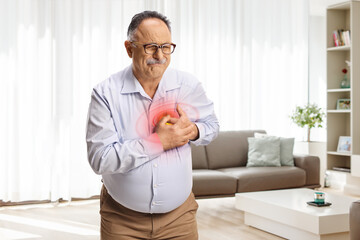 Mature man holding his chest with red spot inflammation at home