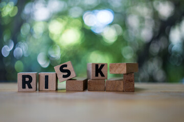 Four wood cubes with black letters spelling RISK. Risk Management and insurance concept, decision to accept business result in uncertainty