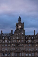 Fototapeta na wymiar Reloj de edificio de Edinburgo por la noche con cielo azul. 