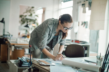 Young female architect working on building designs in the office