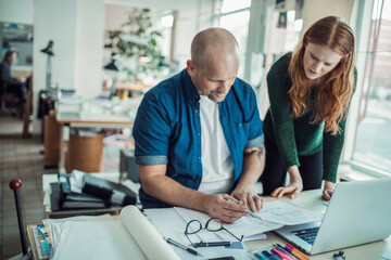 Young man and woman working together on a project in a startup company office