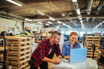 Diverse group of coworkers using a laptop in a warehouse