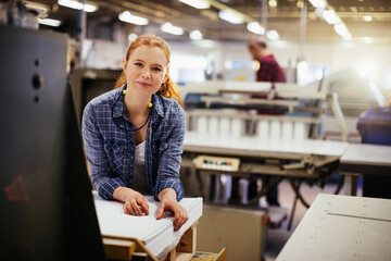 Portrait of a young Caucasian woman working in a printing press office