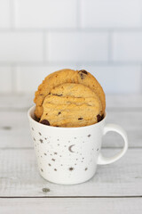 Homemade peanut butter cookies with chocolate chips. Morning breakfast biscuits. Peanut butter cookies stacked on a plate. Close up view. Cookies in a cup. 