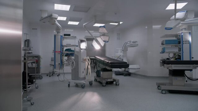 Dolly shot of operating room in modern hospital with advanced equipment for surgery. Operating table, LED lamps, life support and anesthesia machine. Operation block in clinic or medical facility.