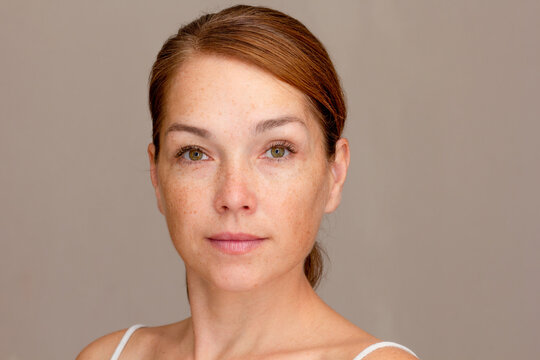 Portrait of caucasian middle aged woman of 40s looking at camera on gray background 
