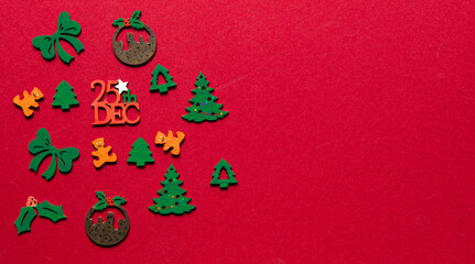Cloloured wooden xmas cutouts isolated on a red background.