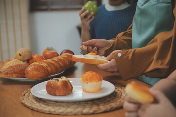 Caucasian attractive couple baking bakery with son in kitchen at home. Happy Family-father, mother and young boy having fun spending time together using ingredient making foods. Activity relationship.