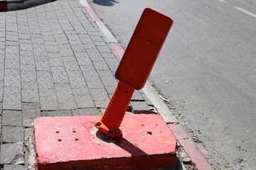 A row of pillars along the road for the safe passage of pedestrians along the sidewalk.