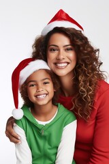 Latin American mom embracing her little boy wearing Christmas hats ands posing over white background