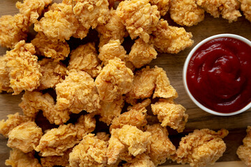 Homemade Crunchy Popcorn Chicken with Ketchup on a Board, top view. Flat lay, overhead, from above.