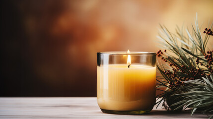 Winter season decoration with green branches. Christmas yellow candle burning and creating cosy atmosphere. Brown background with copy space