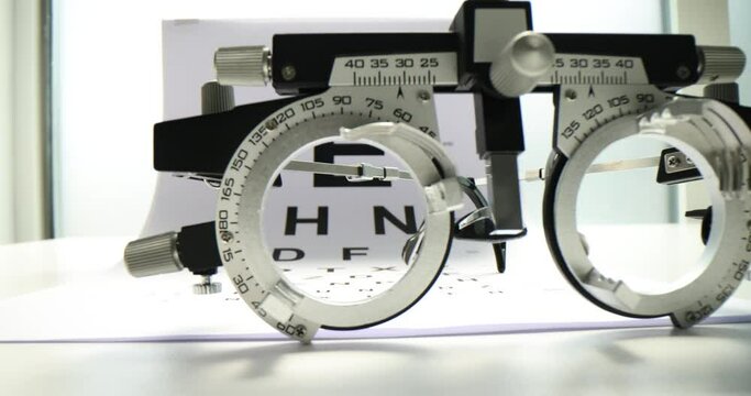 Glasses placed on paper Snellen chart to measure visual acuity. Medical equipment for vision testing waiting for patients in examination room