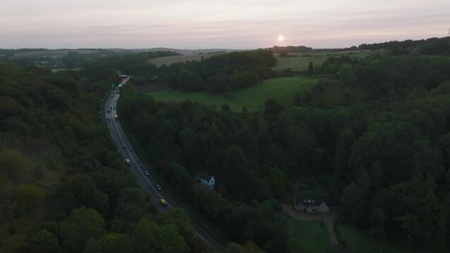 Aerial shot of a busy road through the British countryside at sunrise