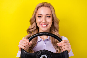Photo of positive cheerful woman dressed violet t-shirt driving automobile isolated yellow color...