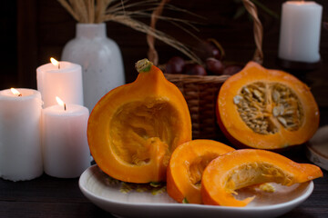 autumn pumpkin sliced on a wooden table. Romantic candlelit dinner, dry spikelets Village Concept