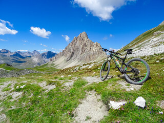 Mountain bike on scenic trail with view of Rocca La Meja near rifugio della Gardetta on Italy French border in Maira valley, Cottian Alps, Piedmont, Italy, Europe. Hiking on sunny summer day in nature