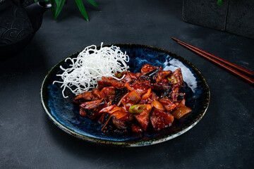 Asian chicken fillet with shiitake mushrooms, onion, celery, sweet pepper, sesame seeds in sauce with chopsticks.