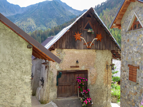 Old decorative stone houses in small remote alpine village of Ferrere in valley Valle Stura in Colle Del Puriac, Piemonte, Italy, Europe. Hiking in Italian Alps in summer. Peaceful serene atmosphere