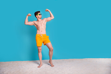 Full size photo of attractive young man flexing muscles demonstrate raise fists wear trendy yellow...