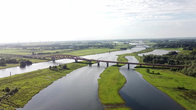 Aerial shot of the Zwolle Railway bridge over the river Ijssel, with a train crossing it on its way to the interior of the Netherlands. Railway crossing at Zwolle in the west of the Netherlands. 4k vi