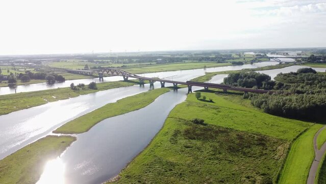 Aerial shot of the Zwolle Railway bridge over the river Ijssel, with a train crossing it on its way to the interior of the Netherlands. Railway crossing at Zwolle in the west of the Netherlands. 4k vi