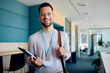 Happy male entrepreneur in office looking at camera.