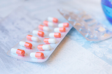 Close image of a pair of medication blister packs, one complete with pills and another completely...