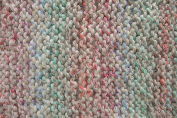 Light pastel colored stripy handmade knitting blanket background.