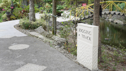 Large square stone information sign with black letters to show directions.