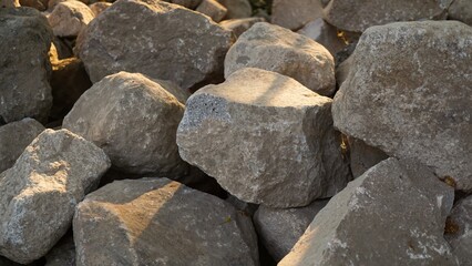 Pile of limestone gravel at a construction site illuminated by sunlight.