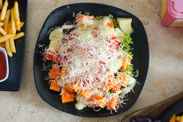 Salad containing papaya, lettuce, watermelon, lettuce, cheese, mayonnaise.