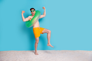 Full body photo of handsome young guy excited flex muscle inflatable ring wear trendy yellow shorts...