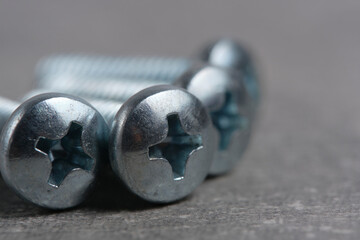Bolts for phillips screwdriver closeup gray background.